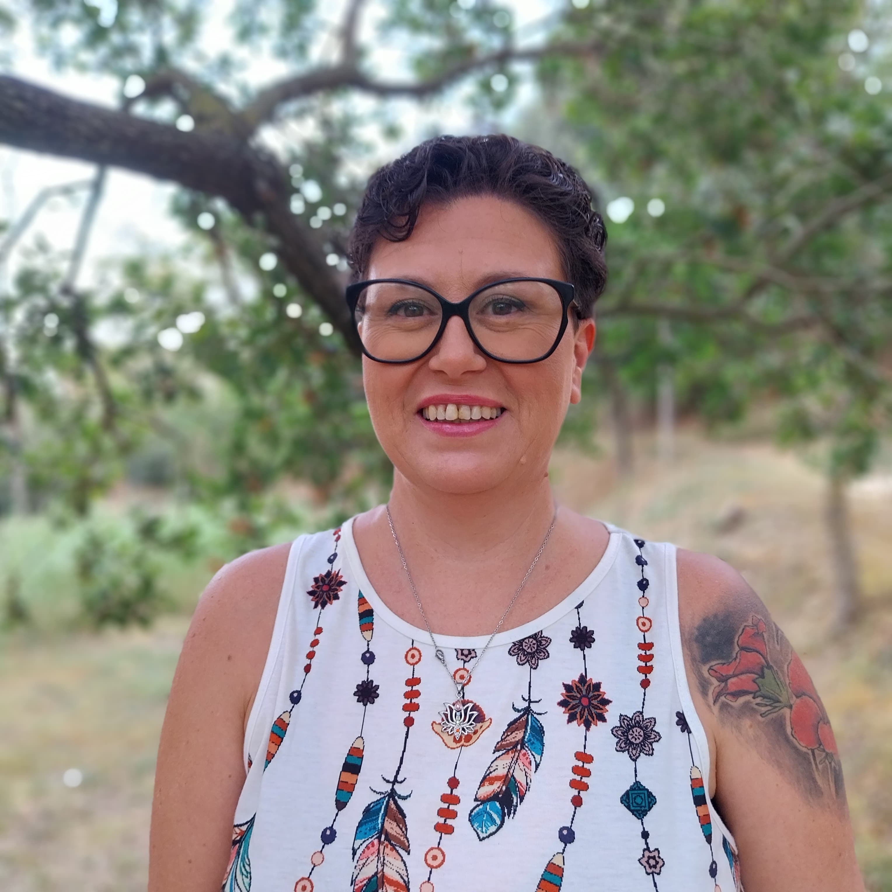 mujer en primer plano rodeada de naturaleza